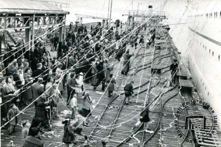 Genova. Al momento della partenza i fili di lana che stanno per strapparsi sono l’ultimo legame con la famiglia che rimane in patria